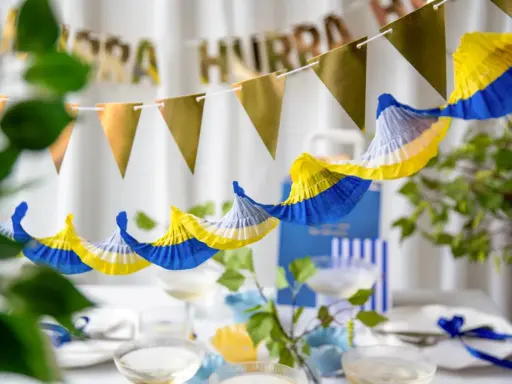 Festlig student dekoration inspiration med girlanger i guld och blått/gult. Perfekt för att fira!