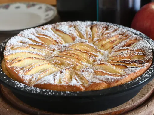 Torta di mele in friggitrice ad aria, dorata e cosparsa di zucchero a velo, pronta per essere gustata.