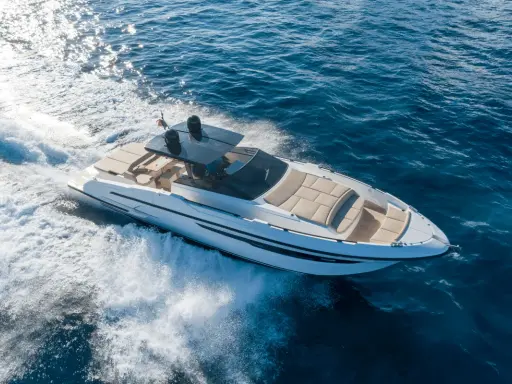 Yacht blanc filant sur l'eau bleue, créant une écume blanche. Idéal pour surveiller son bateau à distance.