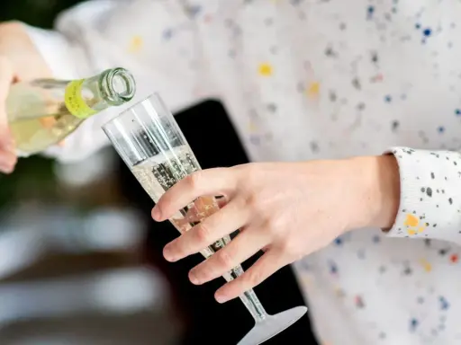 Sekt wird in ein Glas gegossen. Die Frage, wie lange ist Sekt haltbar, beschäftigt viele Genießer.