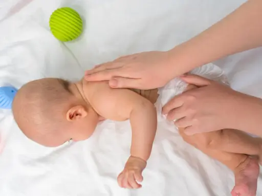 Dziecko na brzuchu ćwiczy mięśnie. Brak tych ćwiczeń może mieć konsekwencje dla rozwoju. Zabawki obok.