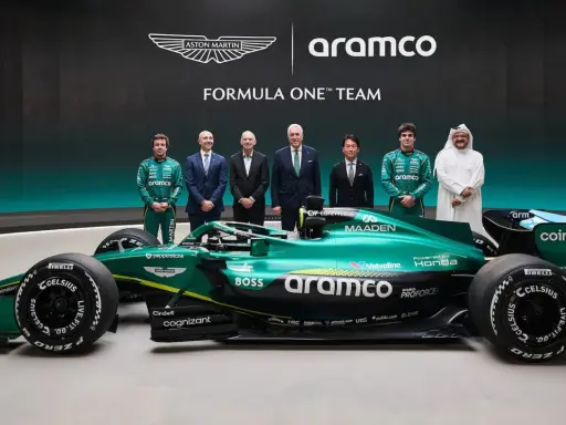 El equipo Aston Martin Aramco Cognizant Formula One Team posa junto a su coche verde brillante.