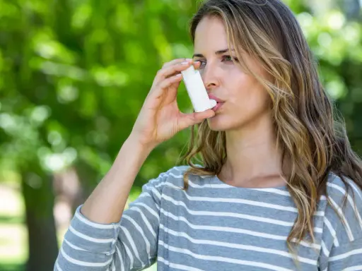 Frau mit Inhalator im Freien. Bei Asthma kann die richtige Dosierung von Prednisolon Tabletten wichtig sein.