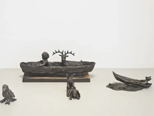Bronsfigurer av Suzanne Nessim: ett barn och ett rådjur i en båt, kaniner och en fågel.