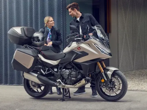 Para zwiedzająca motocykle z automatyczną skrzynią biegów. Nowoczesny design i praktyczne kufry zachęcają do wspólnych podróży.