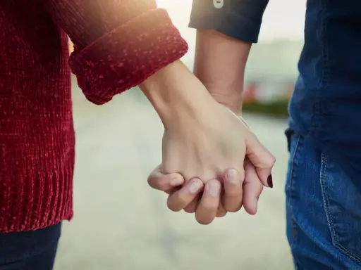 Mani che si stringono, simbolo del significato dell'ancora in amore: stabilità, sicurezza e un legame profondo che resiste alle tempeste.