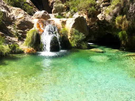 Cascada en la ruta río verde, con aguas cristalinas y vegetación exuberante.