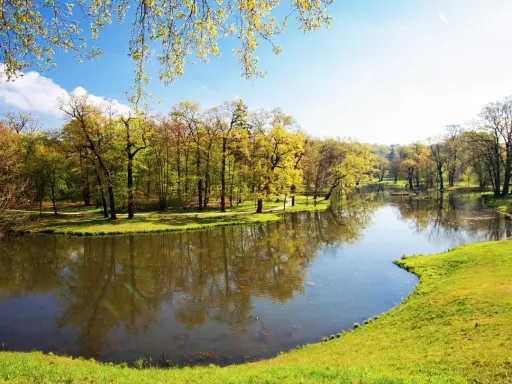 Malowniczy park z jeziorem i drzewami w wiosennej odsłonie. Idealne miejsce na spacer i podziwianie łęknica atrakcje.