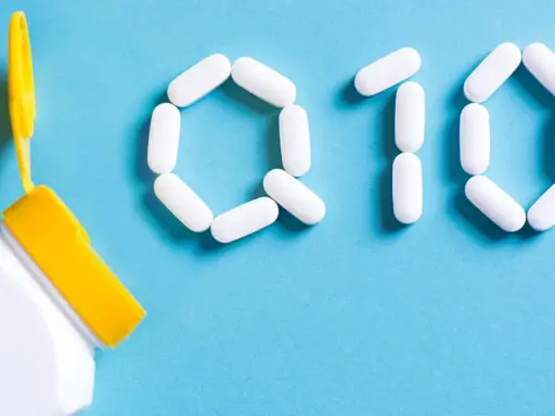 Białe kapsułki ułożone w kształt "Q10" obok otwartego pojemnika. Zastanawiasz się nad koenzym q10 – przeciwwskazania?
