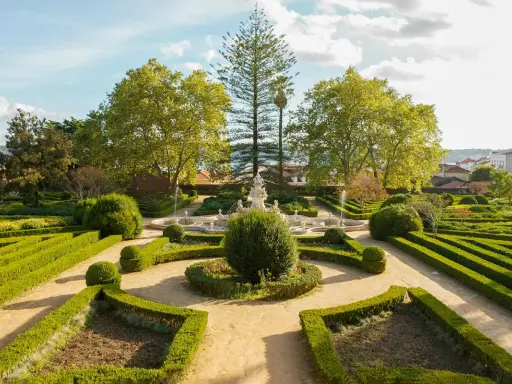 Ein barocker Garten mit Brunnen und akkurat geschnittenen Hecken vor dem Ajuda-Palast in Lissabon.