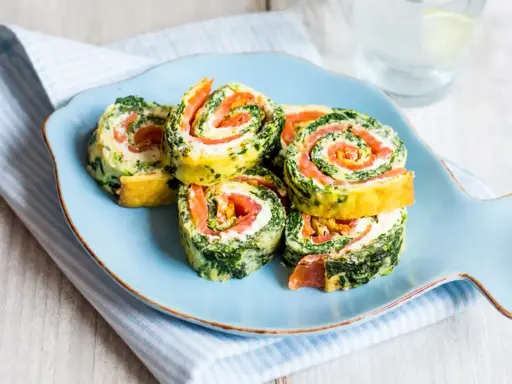Rouladen mit Lachs und Spinat auf einem Fisch-Teller. Leckere Morbus Crohn Rezepte, die gut verträglich sind.