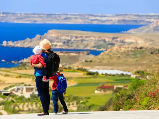 Madre con bambini ammira il panorama di Malta. Un'avventura indimenticabile per tutta la famiglia.