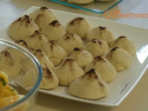 Douceurs de la recette montecao, des biscuits sablés saupoudrés de cacao, prêts à être dégustés.