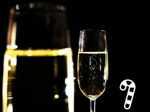Sektglas mit Bläschen und einem Zuckerstangen-Symbol. Die richtige Dosage für den Genuss.