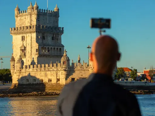 Mann filmt die beeindruckende Torre de Belém, eine der wichtigsten Belem Sehenswürdigkeiten, bei Sonnenuntergang.
