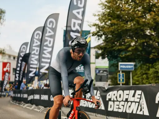 Fokus auf den Radfahrer beim rad wm zeitfahren. Er kämpft sich durch, die Garmin-Fahnen wehen im Hintergrund.