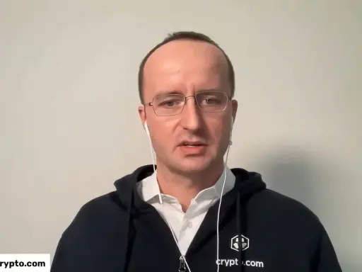 Kris Marszalek, CEO Crypto.com, w okularach i słuchawkach, w czarnej bluzie z logo.