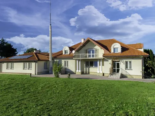 Nowy początek w ośrodku terapii uzależnień i depresji. Dom z czerwonym dachem, otoczony zielenią, zaprasza do spokoju i regeneracji.