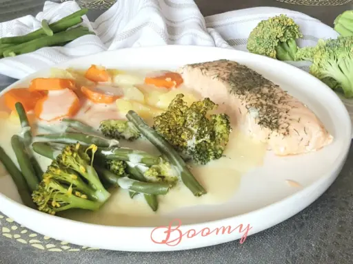 Filet de saumon avec un assortiment de légumes verts, carottes et pommes de terre en sauce crémeuse. Un plat savoureux et coloré.