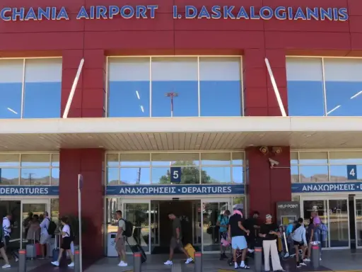 Människor med bagage anländer till Chania flygplats för sina avgångar.