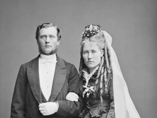 Brudpar i 1800-talets kläder, en viktig del av giftermål historia. Mannen bär frack, kvinnan slöja och blommor.