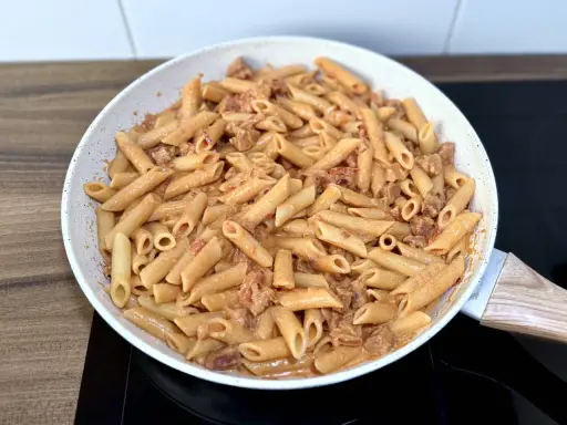 Penne z kremowym sosem i kawałkami pikantnego chorizo, gotowe do podania.