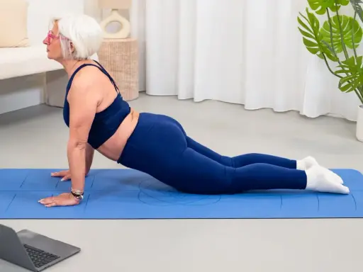 Donne di 50 anni in forma, praticano yoga a casa seguendo un tutorial online.