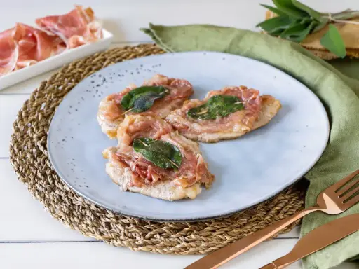 Saltimbocca alla romana ricetta originale: tre fettine di vitello con prosciutto crudo e salvia, pronte per essere gustate.