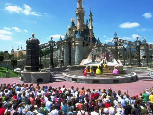 Disneyland Paris con niños: un espectáculo de princesas frente al castillo, con una multitud emocionada disfrutando del día.