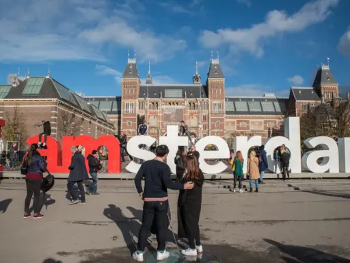 Ludzie pozują przy wielkich literach "I amsterdam" przed Rijksmuseum. Idealne miejsce na pamiątkowe zdjęcie z weekendu w Amsterdamie.