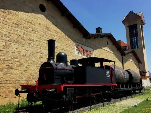 Locomotora antigua frente a las bodegas de Haro, transportando barriles de vino.