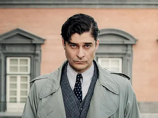 Uomo con trench, camicia a righe e cravatta, con un'espressione seria. Un ritratto creato per mano mia.