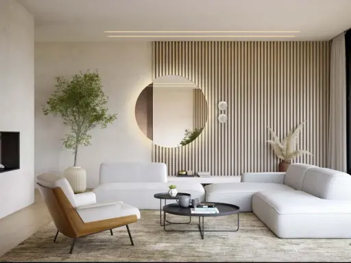 Okrągłe lustro w salonie, podświetlone od tyłu, odbija wnętrze. Obok niego pionowe lamele i nowoczesna sofa.