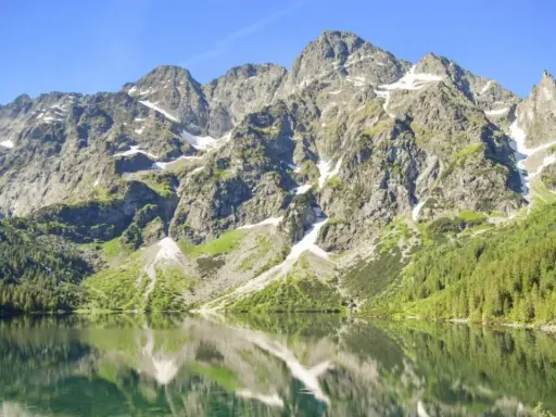 Górskie szczyty odbijają się w tafli Morskiego Oka. To jezioro znajduje się na wysokości 1395 m n.p.m.