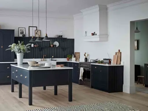 Elegancka kuchnia z ciemnogranatowymi, **czarnymi meblami kuchennymi**. Centralna wyspa i zabudowa tworzą spójną całość.