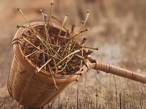 Un panier en osier rempli de tiges sèches, vestiges d'une récolte de cerises. Chaque queue de cerise évoque la douceur de l'été.