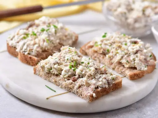 Pyszna pasta z makreli i twarogu na ciemnym pieczywie, posypana szczypiorkiem. Idealna na szybkie śniadanie lub przekąskę.