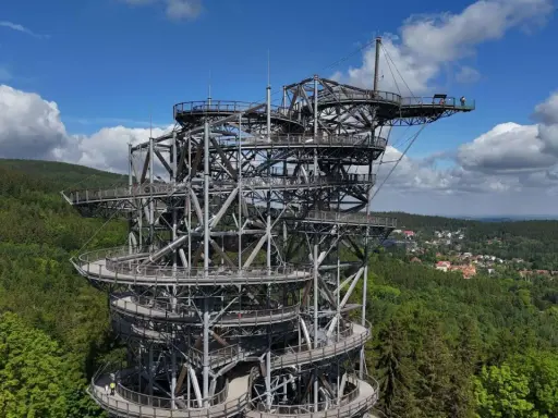 Metalowa konstrukcja z drewnianymi platformami tworzy niezwykły sky walk pośród zielonych lasów. Widok zapiera dech w piersiach.