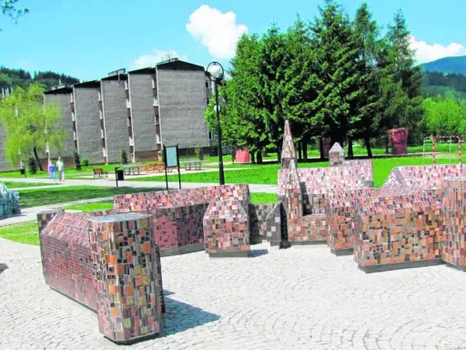 Miniatury budowli z mozaiki, ciekawe wisła atrakcje turystyczne. W tle budynki mieszkalne i zalesione wzgórza.