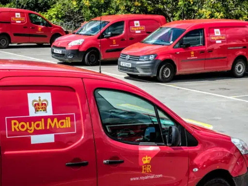 Czerwone furgonetki Royal Mail Polska zaparkowane na placu.