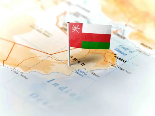 Flaga Omanu wbita w mapę, wskazująca gdzie leży Oman, nad Zatoką Omańską, w pobliżu Maskatu.