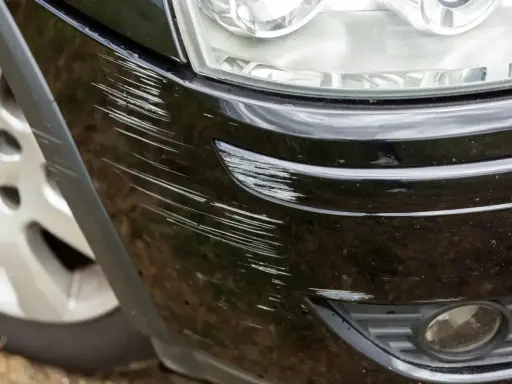 Dużo zarysowań na czarnym lakierze zderzaka. Widać, ile lakieru na zderzak zostało uszkodzone.