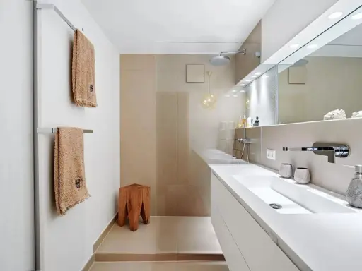 Bagno moderno con lavabo bianco, doccia a pioggia e dettagli in legno. Ottime idee per arredare bagno con stile minimalista.