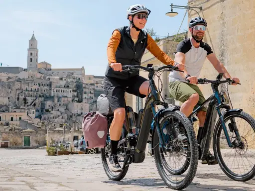 Ein Paar genießt eine Fahrt mit ihrem Buddy Bike durch eine historische Stadt.