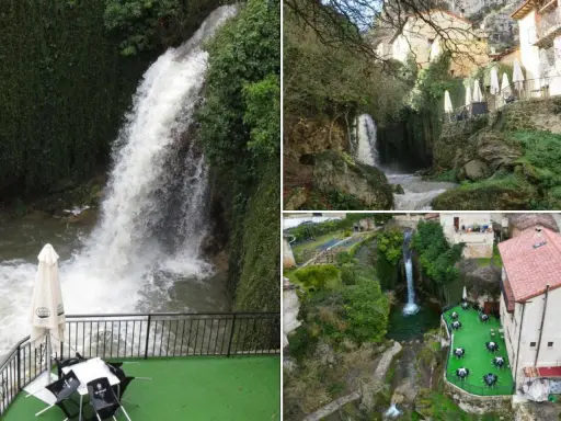 Cascada y terrazas con mesas junto a piscinas naturales en Burgos. Paisaje verde con casas rurales y agua cayendo.