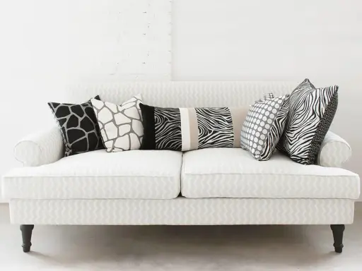 Ecco come mettere i cuscini sul divano: un mix di fantasie animalier e pois per un tocco selvaggio e moderno.