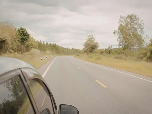 Vista desde un coche en una carretera rural. ¿Cuántos km dura un coche? Depende de su mantenimiento y el camino.