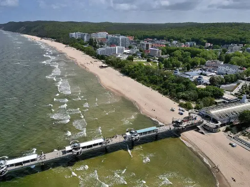 Miejscowości nad Bałtykiem na Pomorzu Zachodnim: plaża, molo, hotele i las.