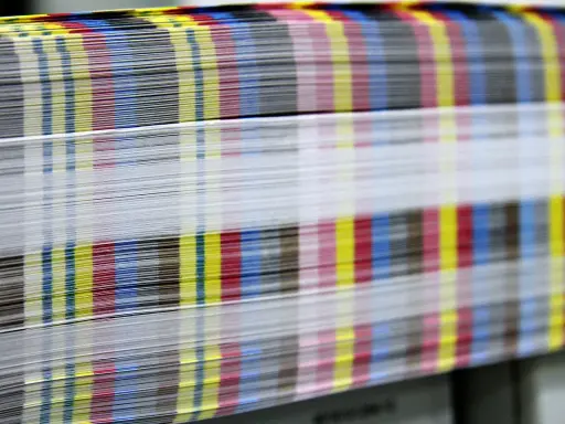 Kolorowe paski CMYK na krawędziach papieru świadczą o pracy w branży poligraficznej.
