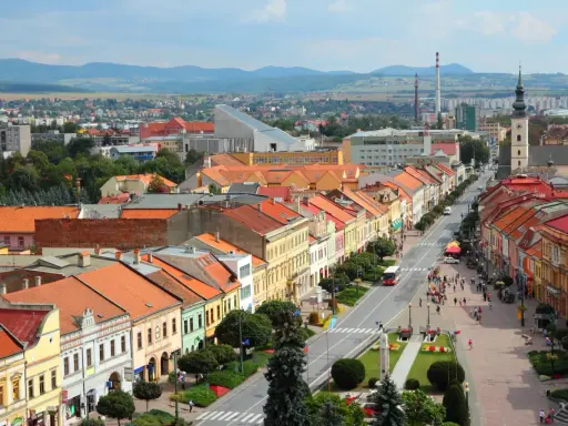 Widok na kolorowe kamienice wzdłuż ulicy, typowe dla największych miast Słowacji. W tle góry i zabudowania.